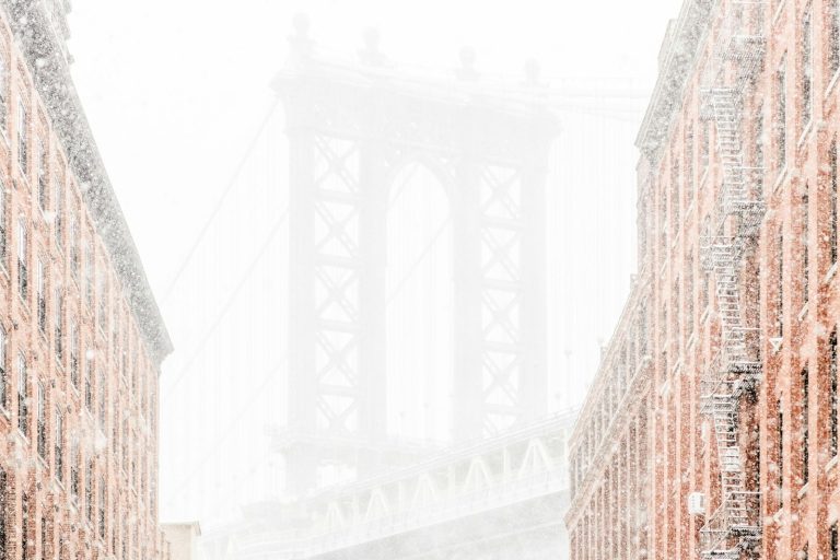 Washington Street in DUMBO in falling snow, with the Manhattan Bridge at the end of the block