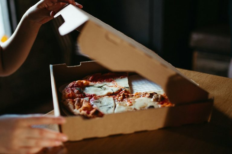 Hand holding a slice of New York pizza